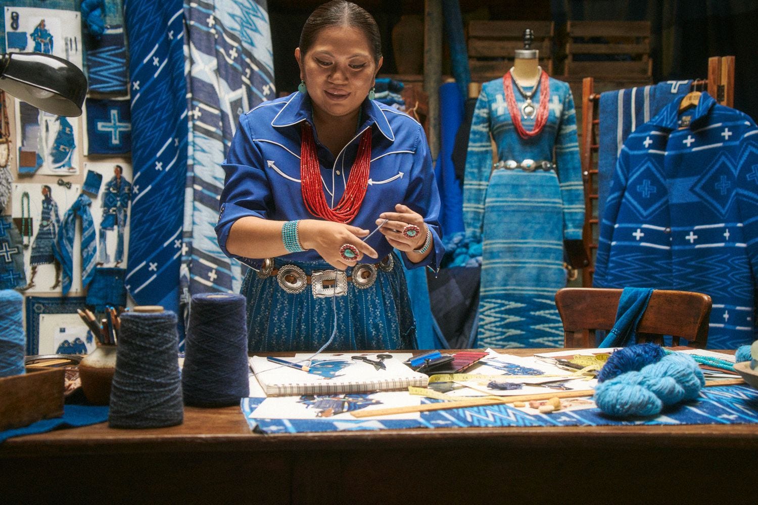A Navajo designer at work in a studio hung with indigo-dyed textiles